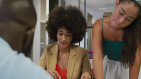 Diverse-male-and-female-business-colleagues-talking-and-holding-documents