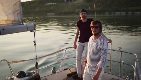 two men enjoying a sailing trip at sunset