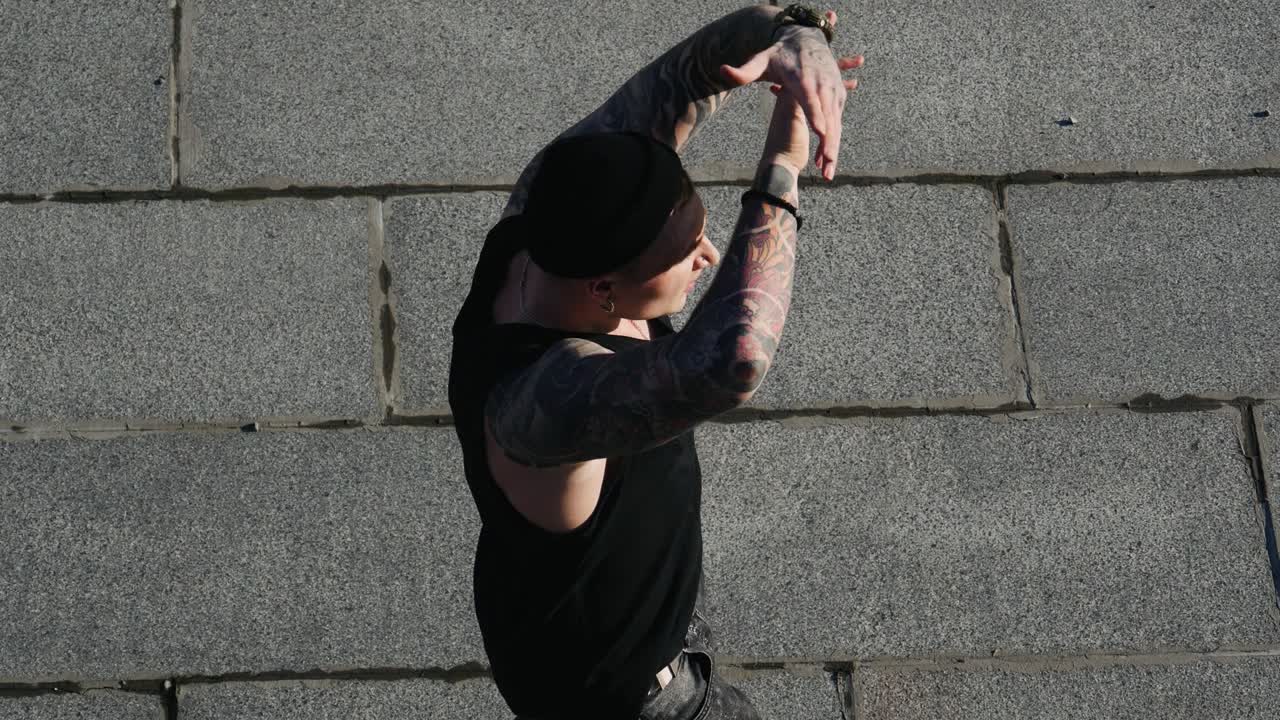Contemporary hip hop street dancer hipster man with tattoo funky urban dancing freestyle in the city