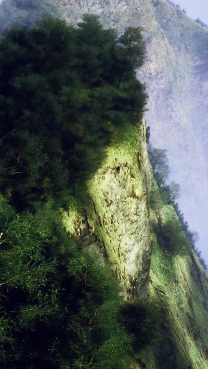 Le montagne mostrano ripide scogliere e alberi verdi di giorno nella natura selvaggia.