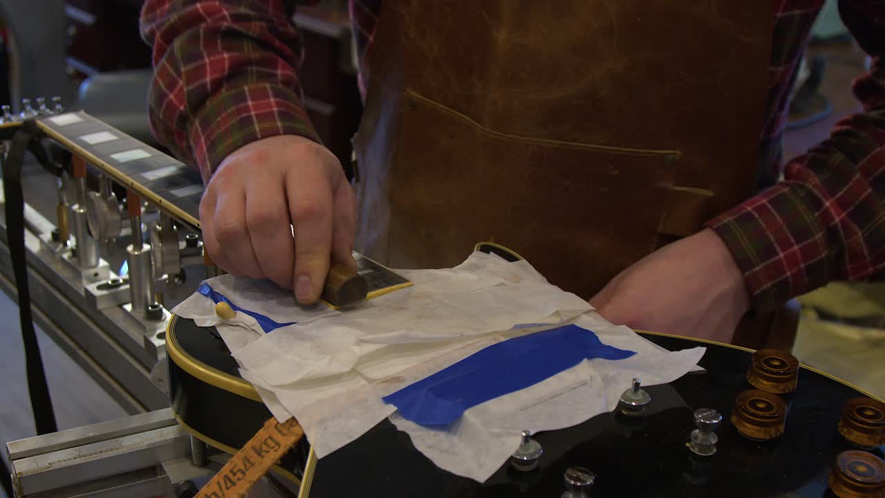 Guitar technician works refret job on classic vintage electric guitar