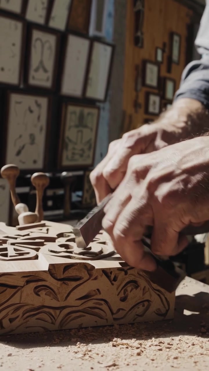 Artigiano del legno che intaglia motivi intricati su un blocco di legno