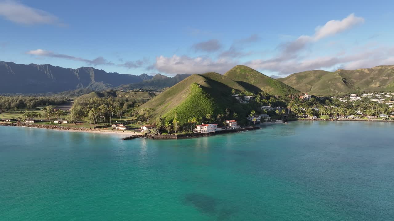 imágenes aéreas de drones de 60 fps de lanikai oahu hawaii al mediodía con hermosas casas de palmeras en las montañas del océano azul y panorámica a la derecha hermosa isla paradisíaca
