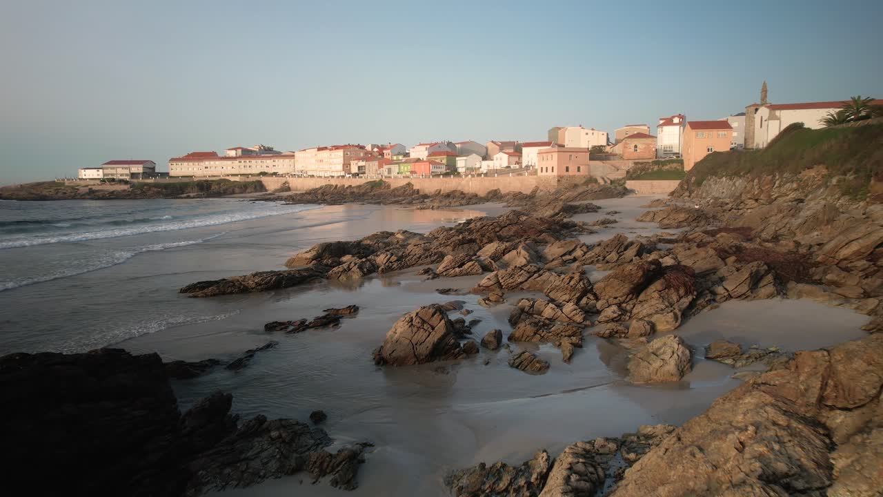 playa rocosa y pueblo costero en un día soleado de verano en a coruña, españa
