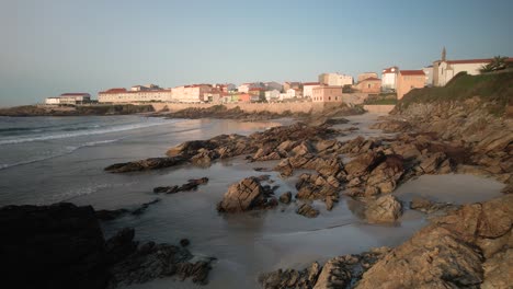 rocky beach and coastal village on a sunny summer day in a coruna, spain