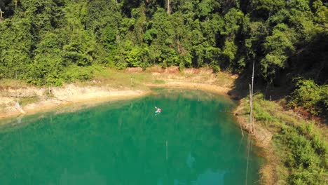 Paddeln-über-Den-Wunderschönen-Türkisfarbenen-See-Neben-Dem-üppig-Grünen-Waldberg-In-Thailand---Mavic-drohnenaufnahme