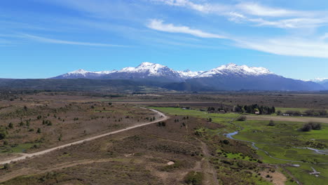 Patagonia wilderness with snowcapped mountains, vast plains, streams, and blue skies