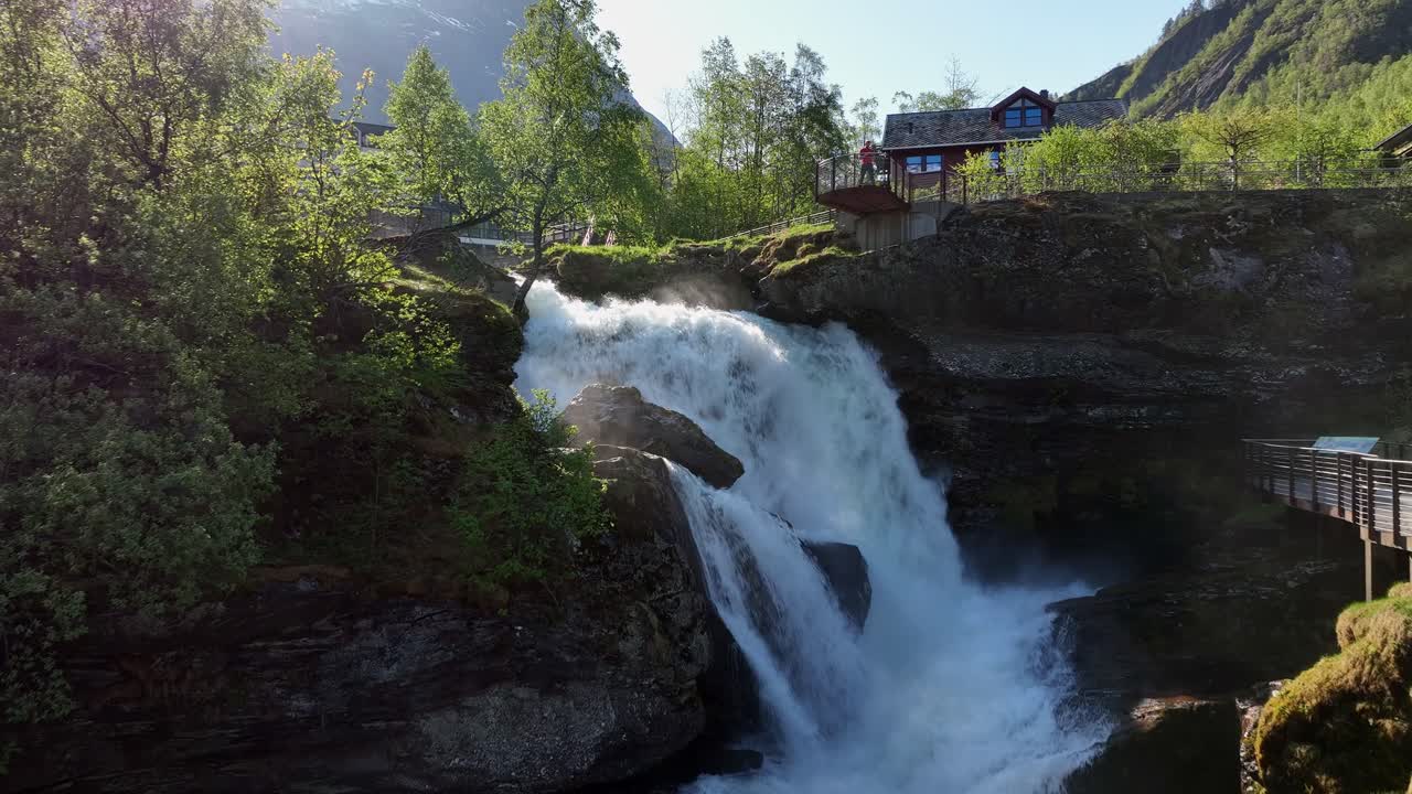 Osoba na vyhlídkové plošině nad fjordem v Geirangeru, Norsko.