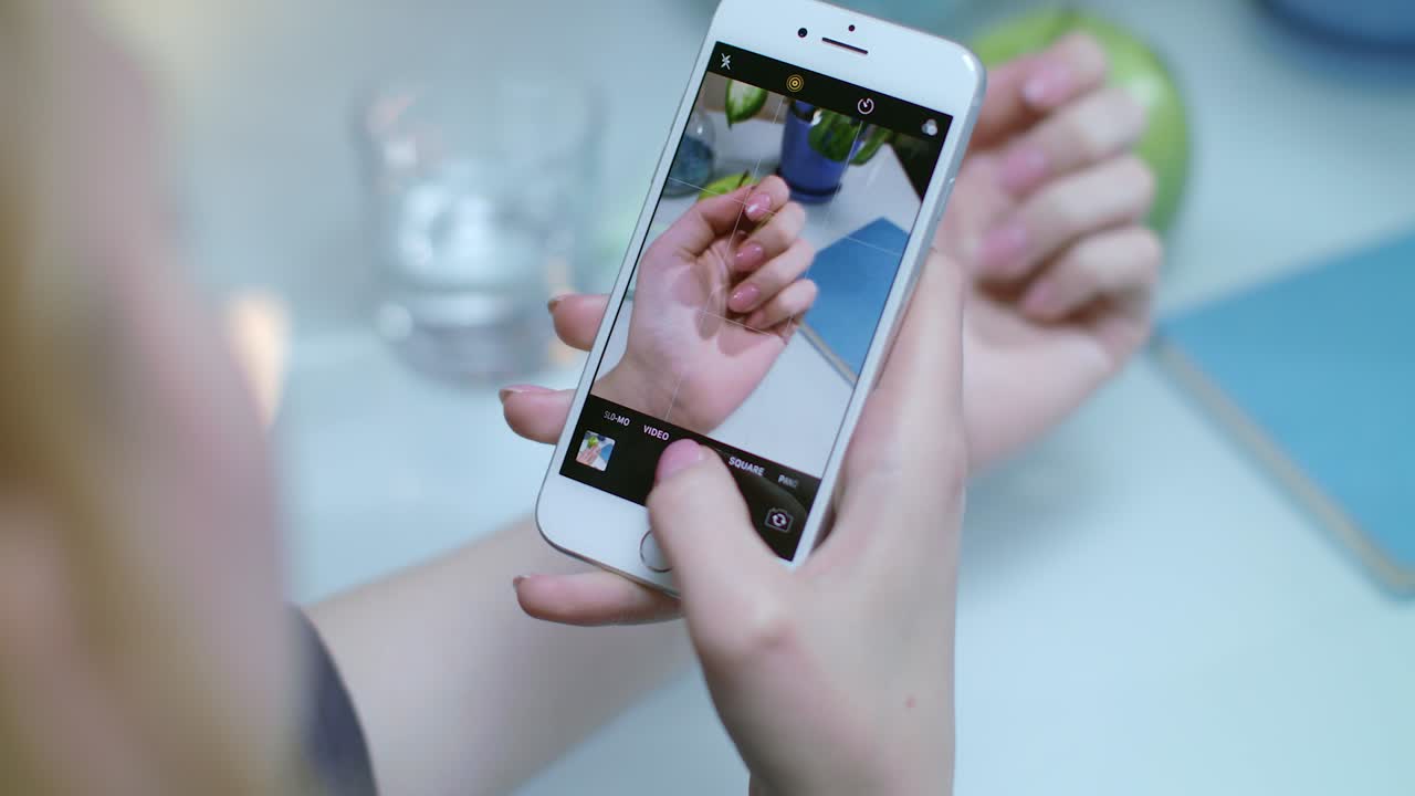 foto de manicura de mujer en el teléfono móvil. foto de manos con esmalte de uñas
