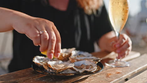 woman eating oysters with champagne