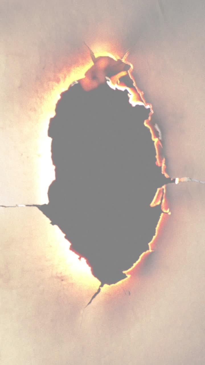 Close-Up of Paper Burning and Creating a Fiery Hole