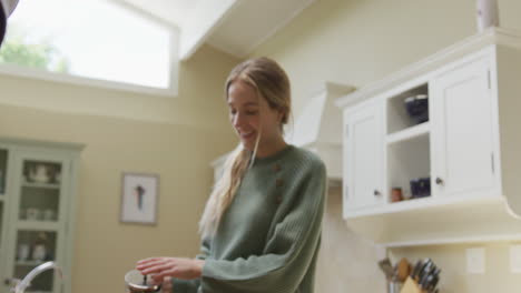 una pareja feliz y diversa sonriendo y dando flores en casa.