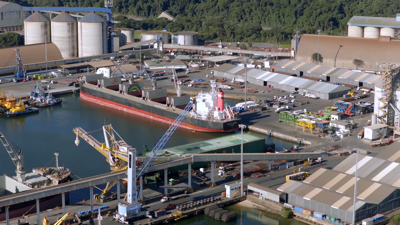 Detailed low-altitude drone shot captures large transport vessel, cranes, and industrial port activity, São Francisco do Sul, Santa Catarina