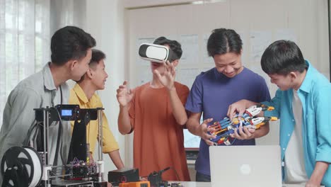grupo de jóvenes asiáticos con impresión 3d y una computadora portátil trabajando en casa, tres niños disfrutan trabajando en el metaverso mientras dos niños discuten sobre una mano ciborg
