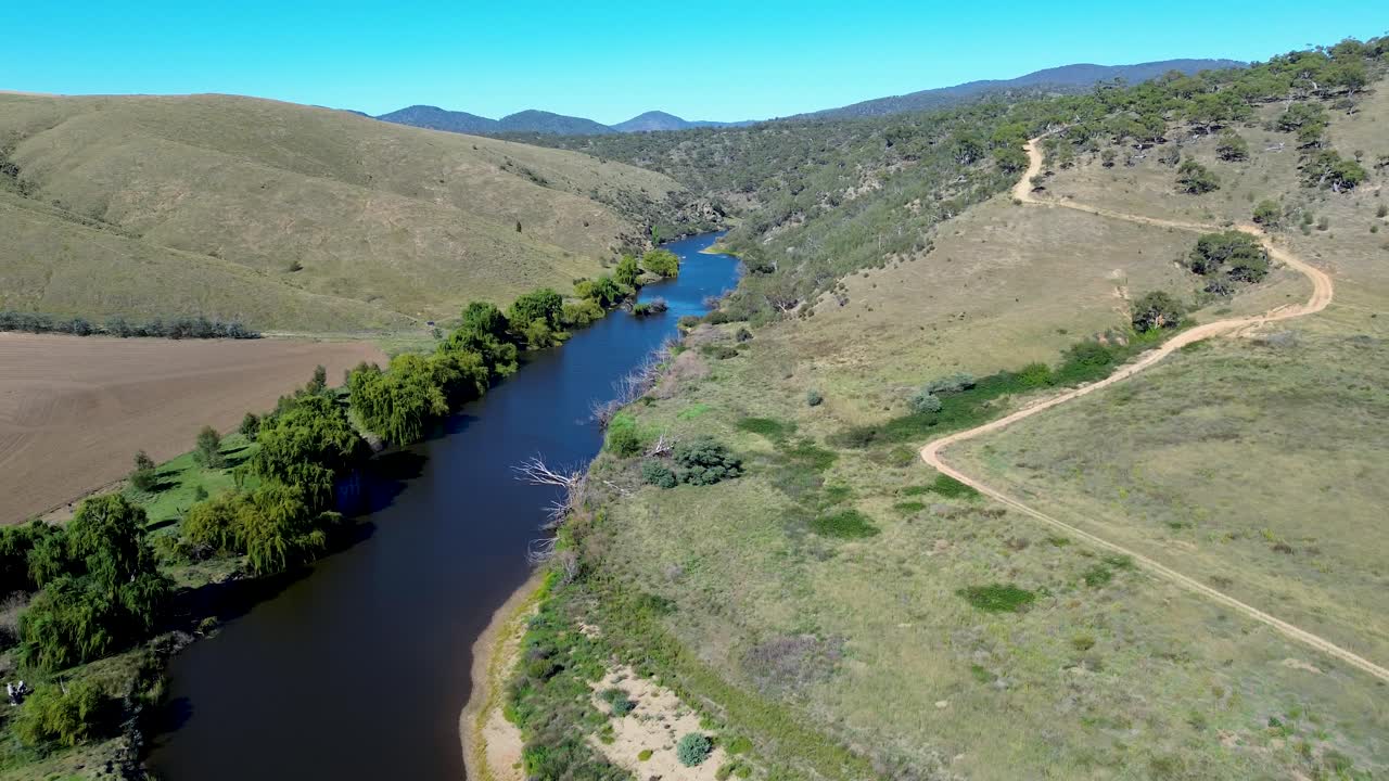 Drone aerial landscape of Murrumbidgee River water creek stream in Bredo valley with mountains trees on embankment and forest bushland Australia travel tourism nature outdoors riverbed