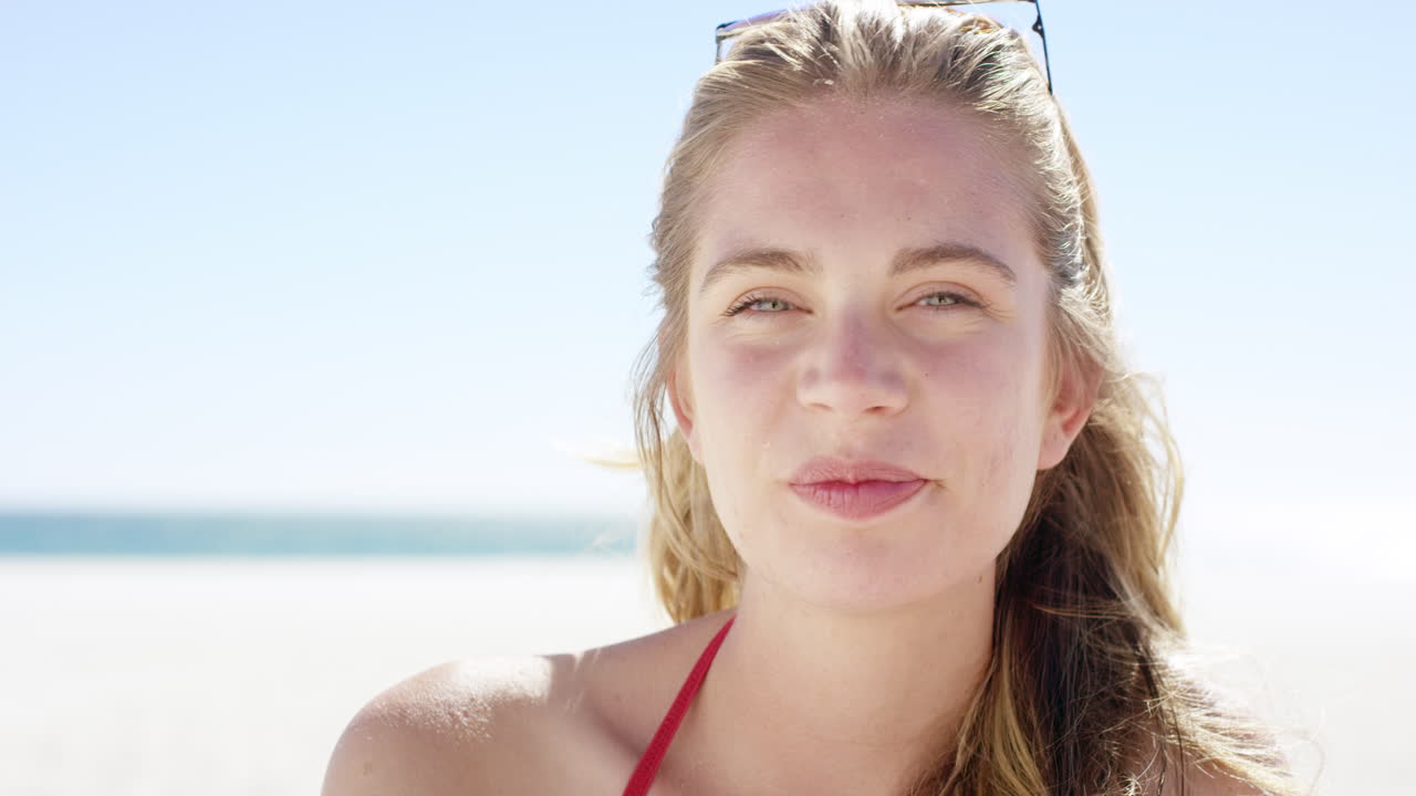 Ritratto ravvicinato di una bella giovane adolescente che sorride su una spiaggia tropicale, al rallentatore