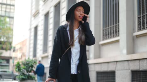 stylish hispanic woman talking on smartphone