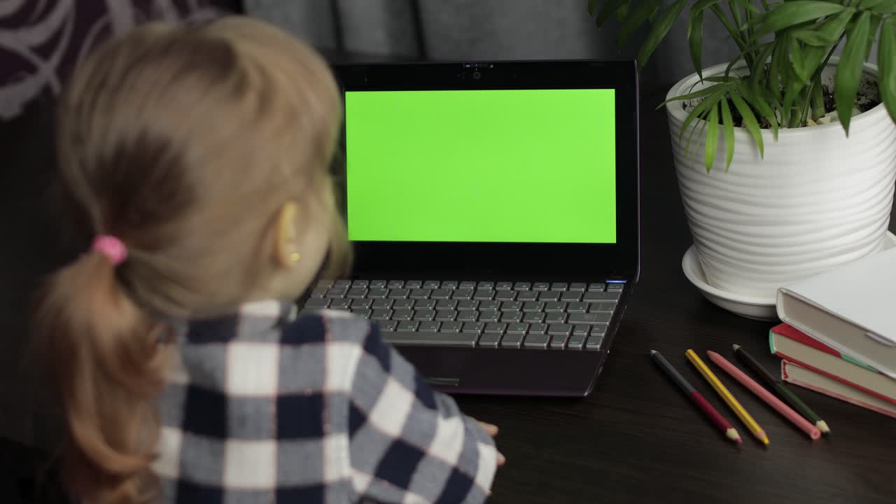 educación a distancia de los niños en la computadora portátil durante la lección en línea en casa. pantalla verde