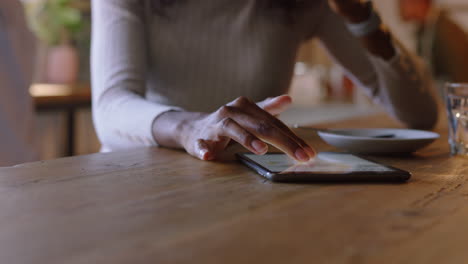 Mujer-De-Negocios-Afroamericana-Usando-Una-Tableta-En-Una-Cafetería-Tomando-Café-Navegando-Leyendo-Mensajes-De-Correo-Electrónico-En-Línea-En-Un-Dispositivo-De-Pantalla-Táctil-Disfrutando-De-La-Tecnología-De-Comunicación-Móvil-De-Cerca-Las-Manos