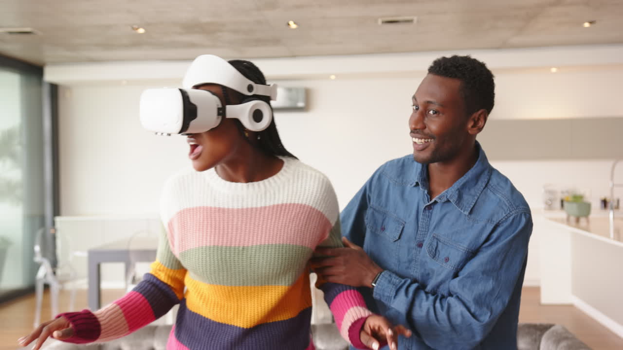 Using VR headset, woman guided by man in modern living room, at home