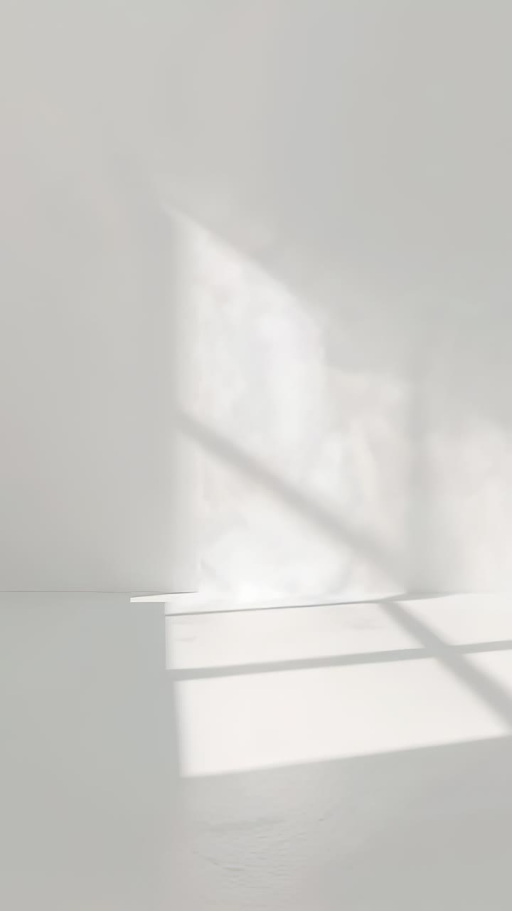 Video verticale: proiezione di chiazze di sole che si spostano con il passaggio delle nuvole nell'angolo bianco con ombre della finestra