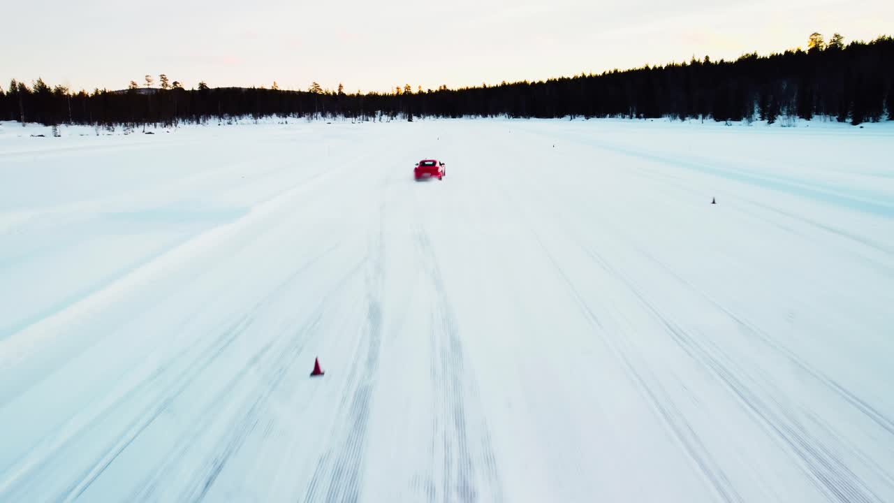 얼음 위에서 회전을 운전하는 빨간색 스포츠카의 드론 샷