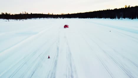 drone shot of red sports car driving slalom on ice