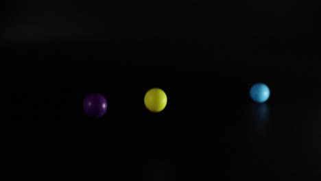 three balls bouncing in a dark space