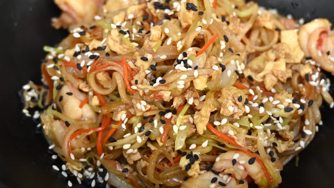 Gros plan de nouilles aux crevettes dans une assiette noire
