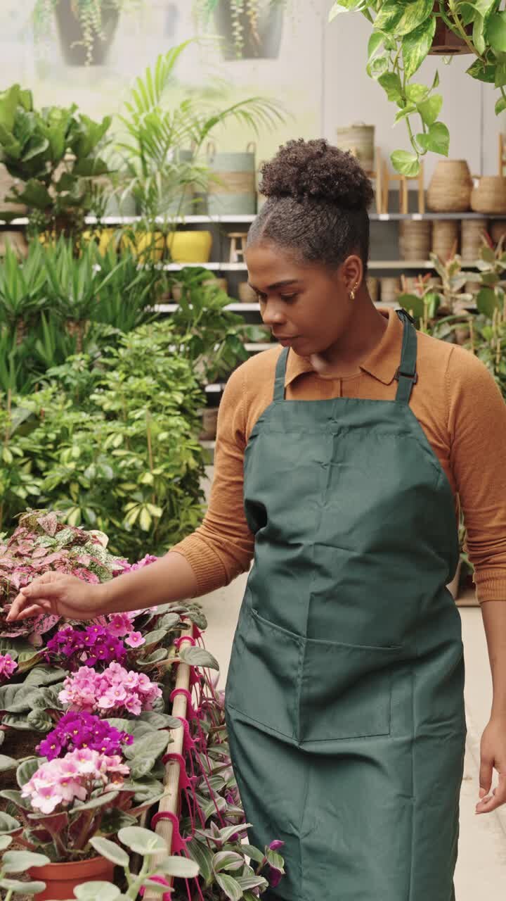 A woman tending to flowers indoors