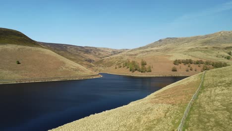 aerial shot of kinder reservoir showing the climb up the valley to kinder scout peak, peak district, uk