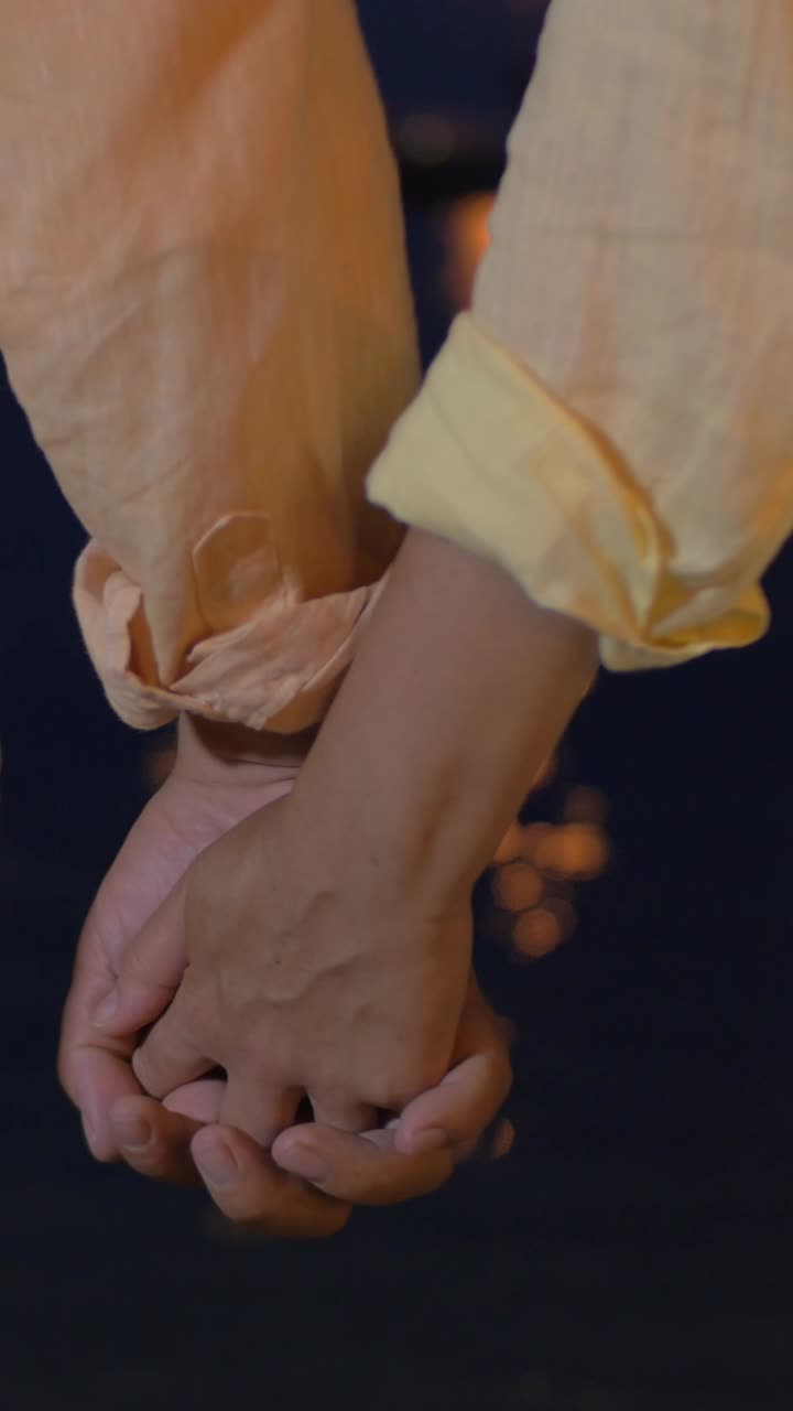 Couple holding hands at night