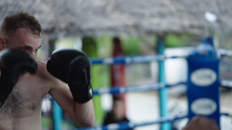 man training in boxing gloves in a ring