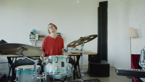 musicians practicing in a studio with drums and keyboard