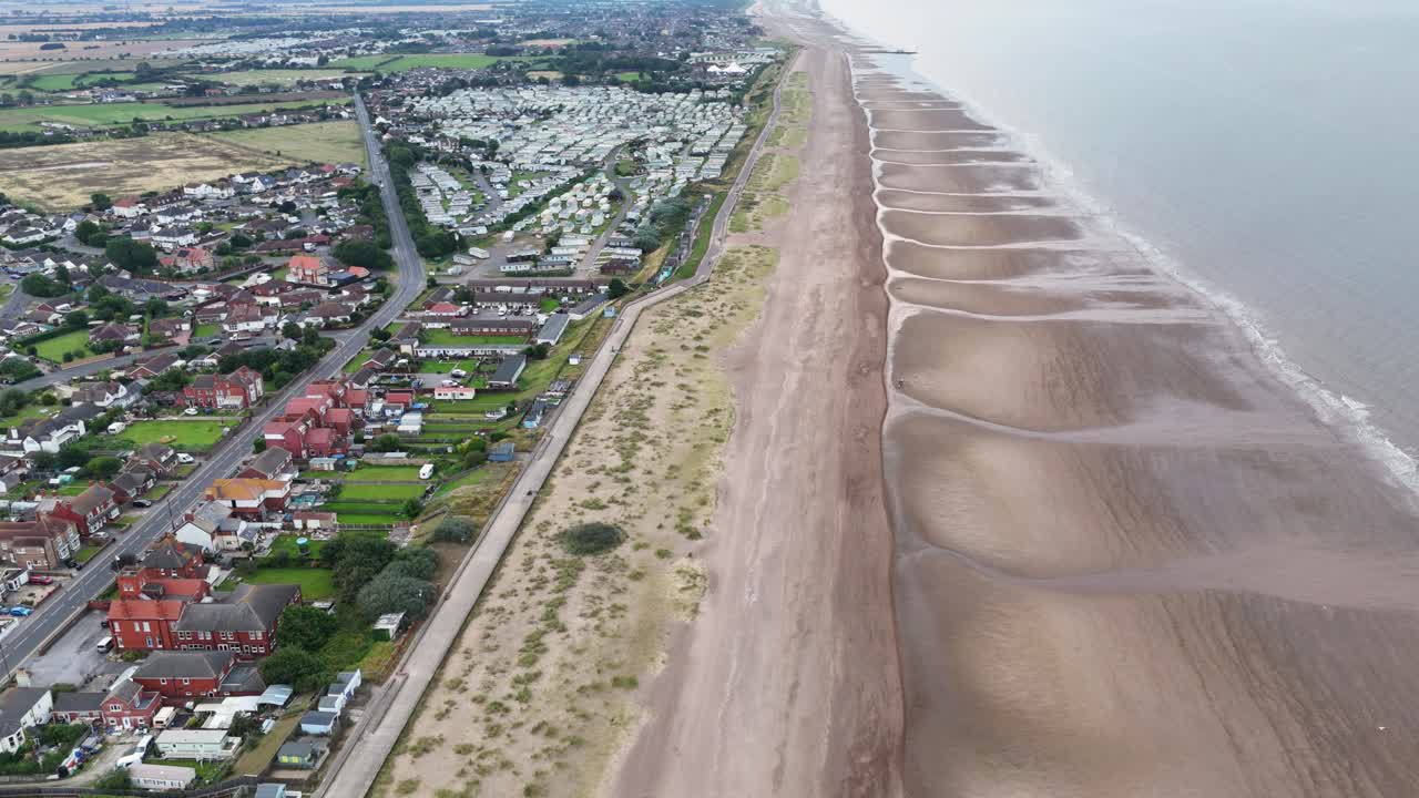 Beautiful aerial view of the long narrow golden beach at Sutton-on-Sea on the Lincolnshire coast in the UK showing how clean the sand is and the gentle incoming tide.