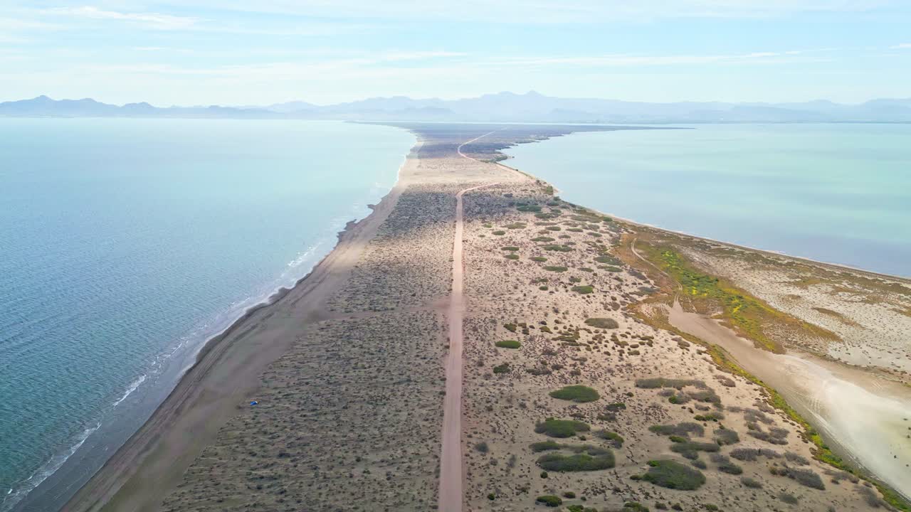 Endless desert road on narrow sandy strip between sea and bay, La Paz, Mexico