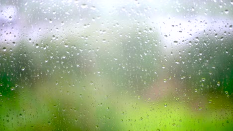 gotas de lluvia en el vidrio de la ventana con fondo borroso movimiento lento