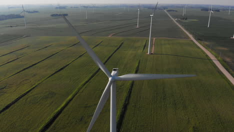 aerial video lowering down on a wind generating spinning on a hot summer day in the midwest