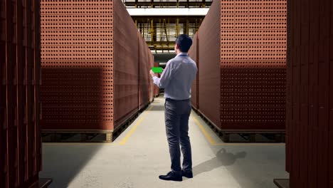 businessman inspecting brick inventory in warehouse