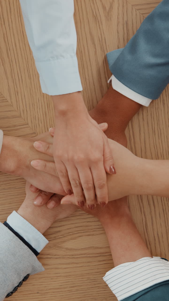 Team aziendale eterogeneo che unisce le mani in segno di unità e collaborazione