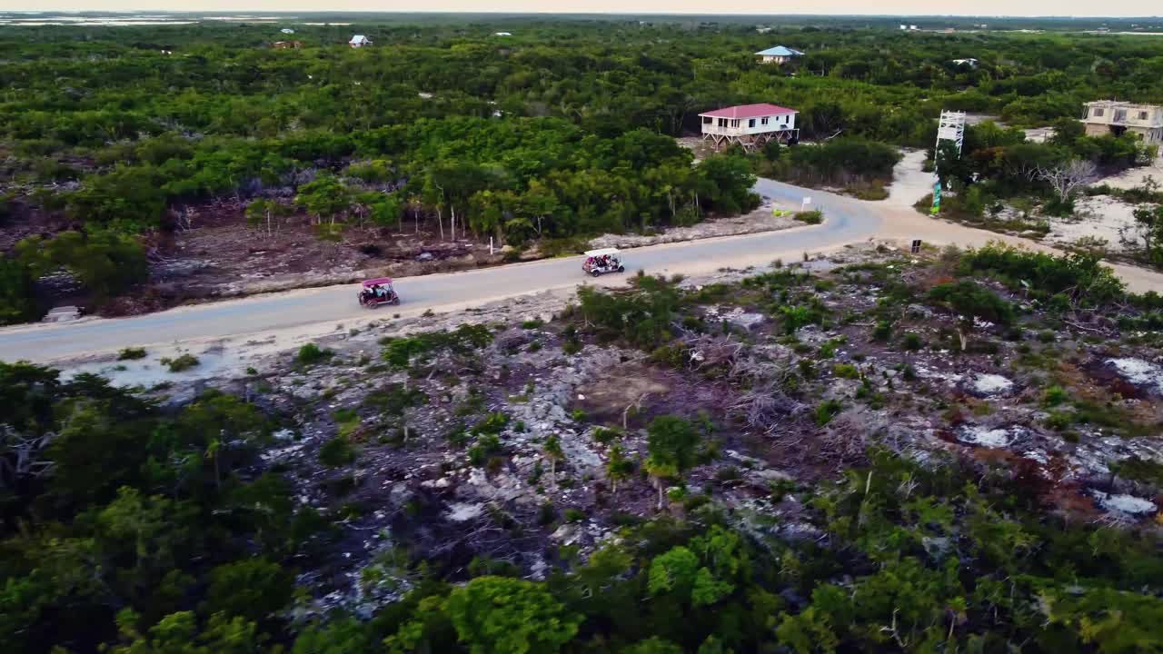 Aerial following golfcarts used by tourists near the 'Secret Beach Belize' on Ambergris Caye or Bay, Belize
