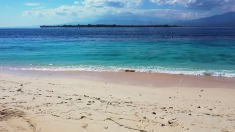 tropical beach with white sand mountains in the background