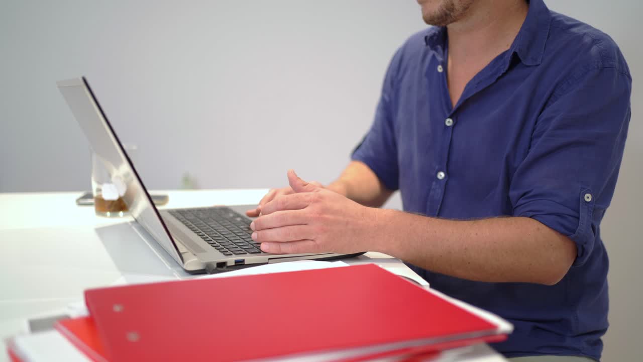 hombre anónimo trabajando en una computadora portátil en la oficina