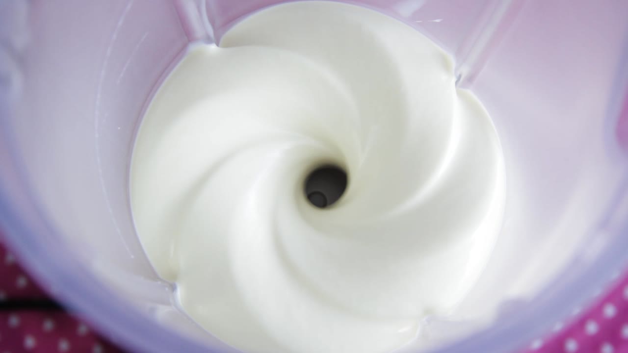 блендер, перемешивающий густую белую жидкость на высокой скорости - вид сверху