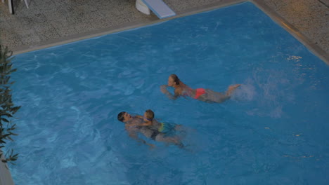 Padre-Madre-E-Hijo-Bañándose-En-La-Piscina