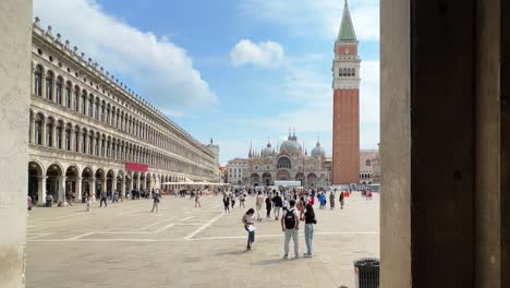 revealing a busy day in st. mark's square with tourists and the iconic basilica under a bright blue sky
