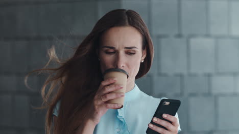 business woman using smartphone in city. manager standing on street with coffee