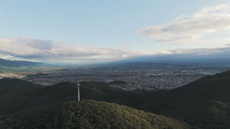 aerial of antenna on green mountains surrounding capital city of salta