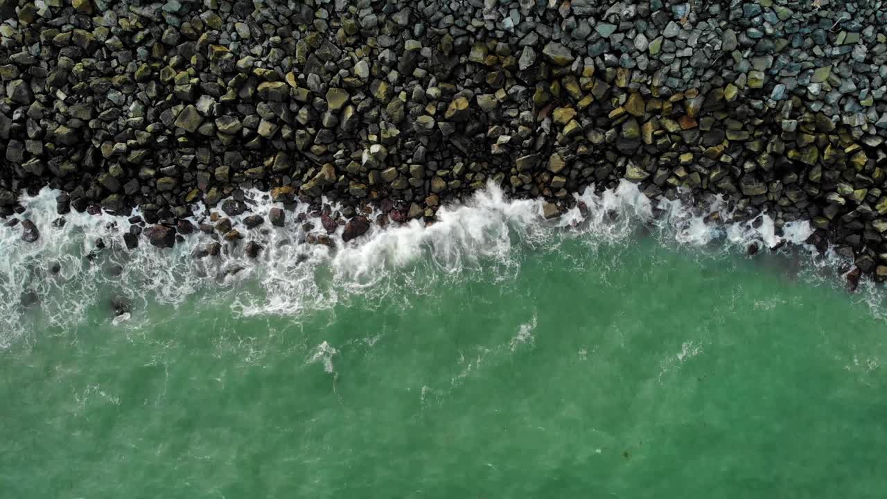 vista aérea sobre las olas turquesas que bañan una costa rocosa, en mackay, australia - de arriba hacia abajo, disparo de drones