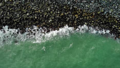 Vista-Aérea-Sobre-Las-Olas-Turquesas-Que-Bañan-Una-Costa-Rocosa,-En-Mackay,-Australia---De-Arriba-Hacia-Abajo,-Disparo-De-Drones